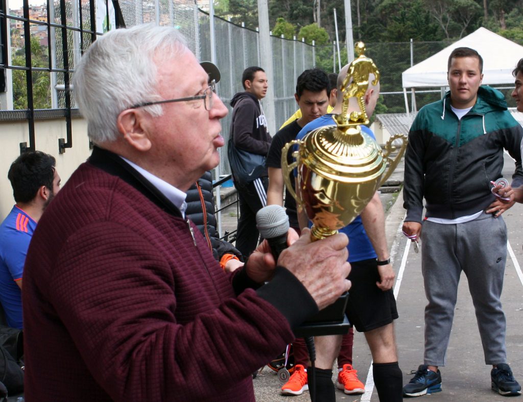 El Padre Donaldo Ortiz S.J. hace entrega del trofeo al equipo Campeón